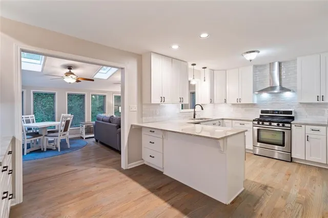 a kitchen with stainless steel appliances kitchen island granite countertop a stove a sink and a refrigerator