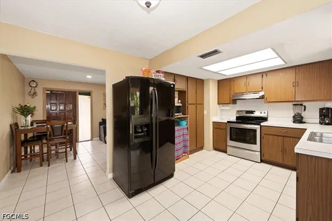 a kitchen with granite countertop a refrigerator and a stove top oven