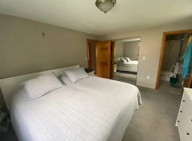 a bedroom with a bed and a mirror