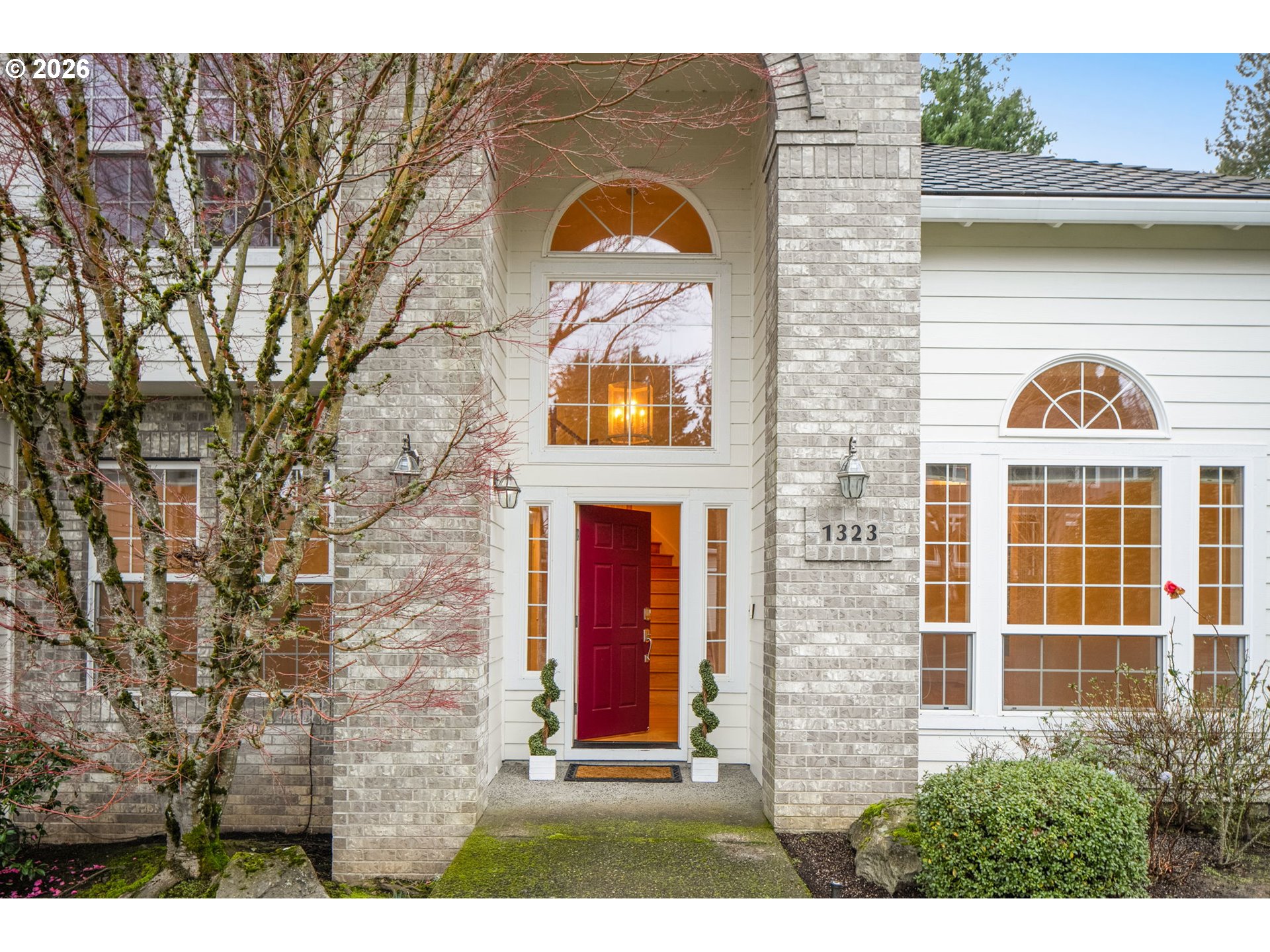 1323 Northwest Mayfield Road Portland, OR 97229 - Photo 2 of 32 a view of a brick house with windows and a large tree