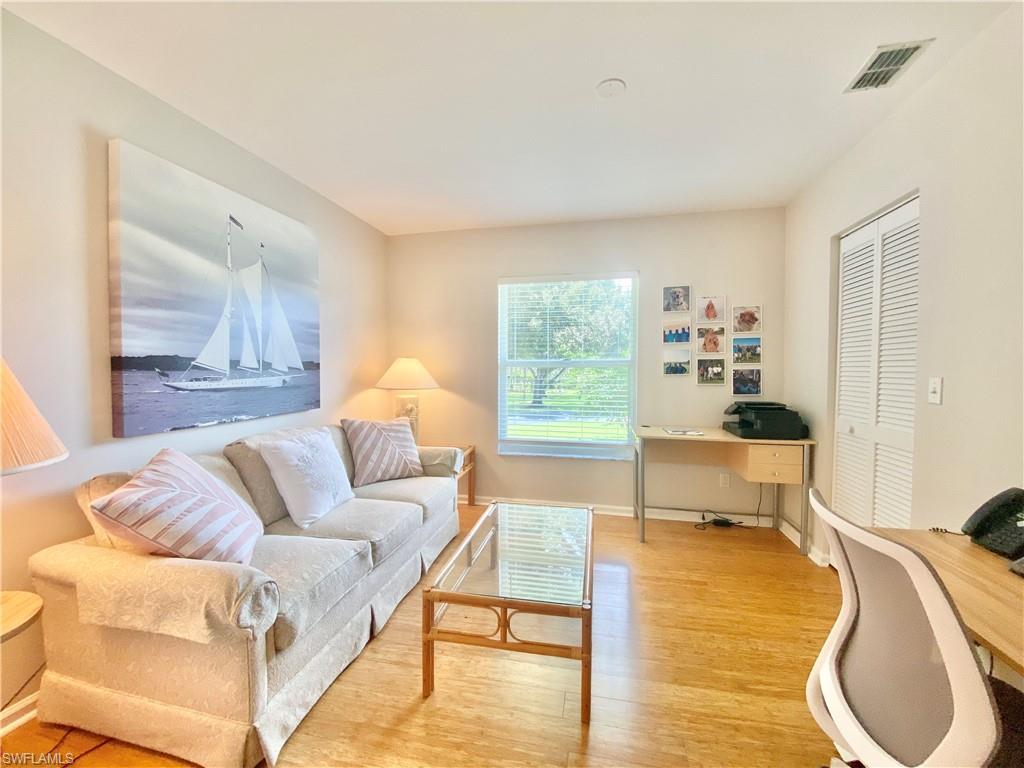 5735 Whitaker Road, Unit B201 Naples, FL 34112 - Photo 11 of 26 a living room with furniture and a lamp