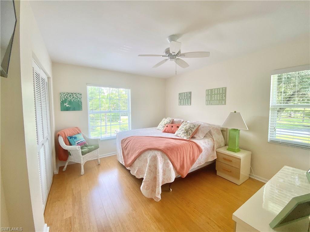 5735 Whitaker Road, Unit B201 Naples, FL 34112 - Photo 12 of 26 a bedroom with a bed and wooden floor