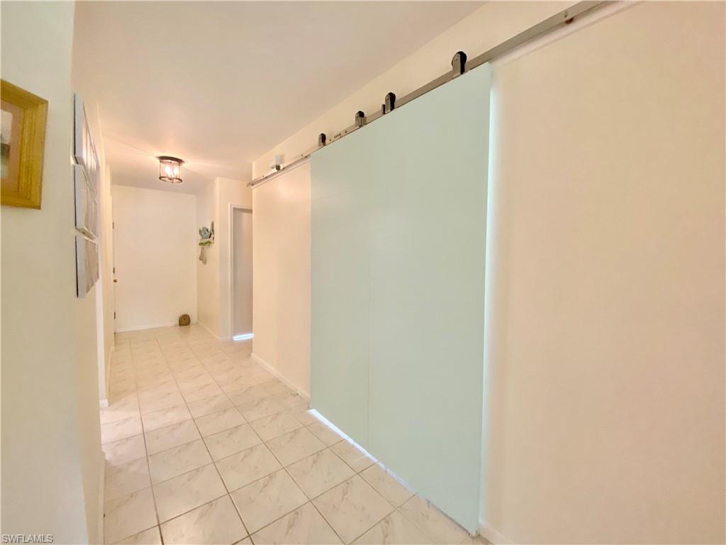 5735 Whitaker Road, Unit B201 Naples, FL 34112 - Photo 14 of 26 a bathroom with a shower and a glass door