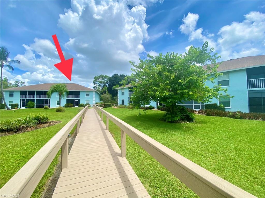 5735 Whitaker Road, Unit B201 Naples, FL 34112 - Photo 25 of 26 a view of house with swimming pool and green space