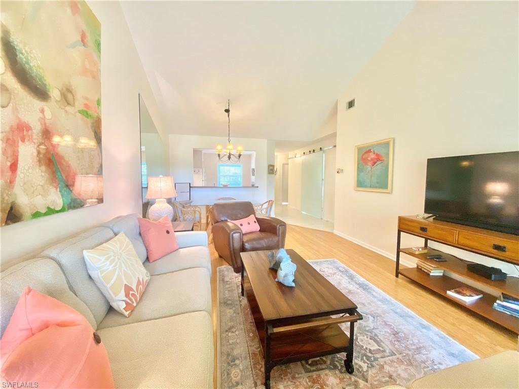 5735 Whitaker Road, Unit B201 Naples, FL 34112 - Photo 3 of 26 a living room with furniture and a flat screen tv