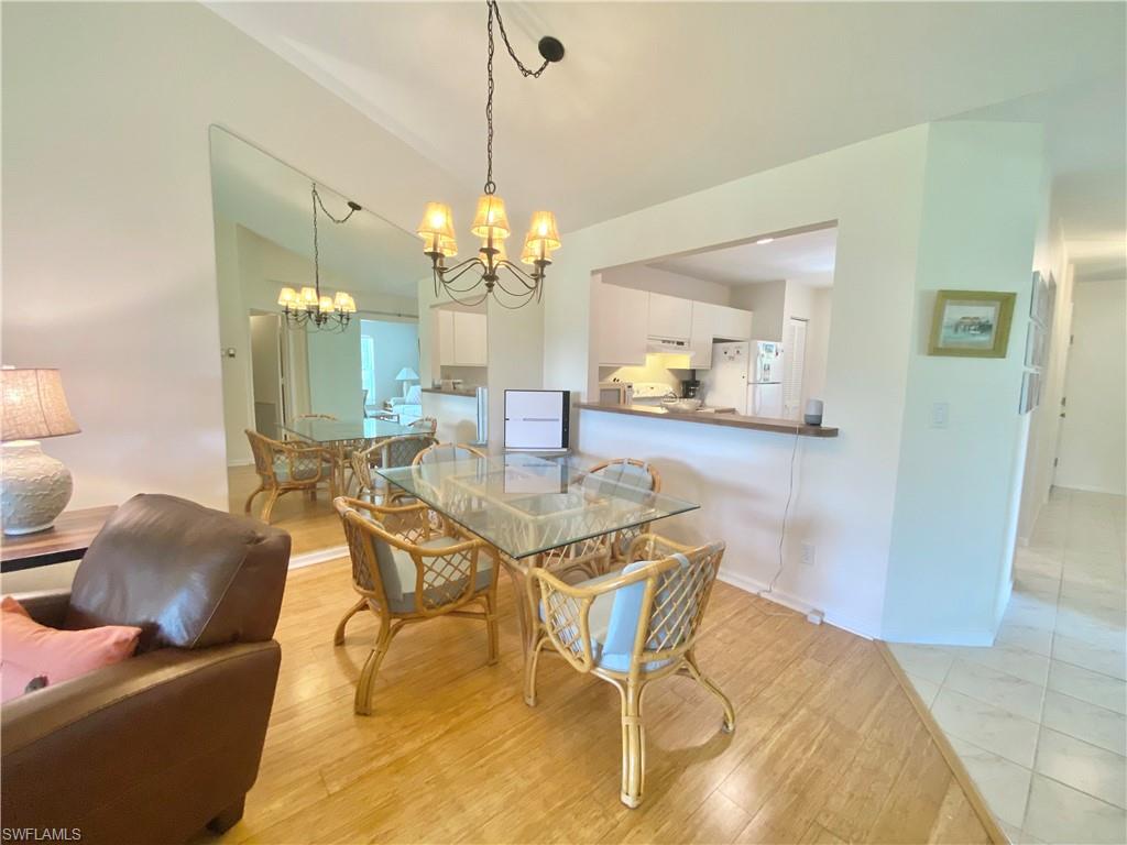 5735 Whitaker Road, Unit B201 Naples, FL 34112 - Photo 4 of 26 a view of a dining room with furniture and a chandelier