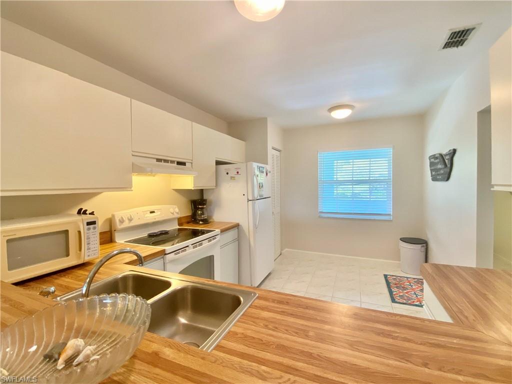 5735 Whitaker Road, Unit B201 Naples, FL 34112 - Photo 5 of 26 a view of a kitchen with a sink cabinets and a wooden floor