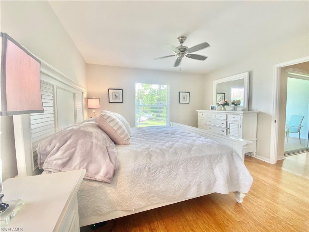 5735 Whitaker Road, Unit B201 Naples, FL 34112 - Photo 8 of 26 a large bed sitting in a bedroom and a chandelier