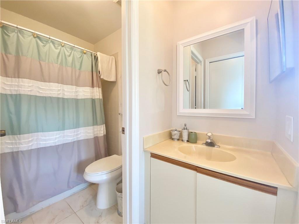 5735 Whitaker Road, Unit B201 Naples, FL 34112 - Photo 9 of 26 a bathroom with a sink a toilet and shower