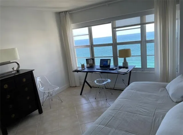 a view of house with roof deck and palm trees