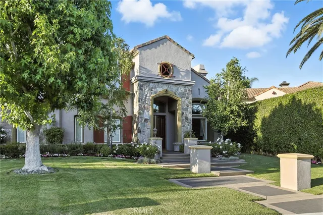 a front view of a house with garden and trees