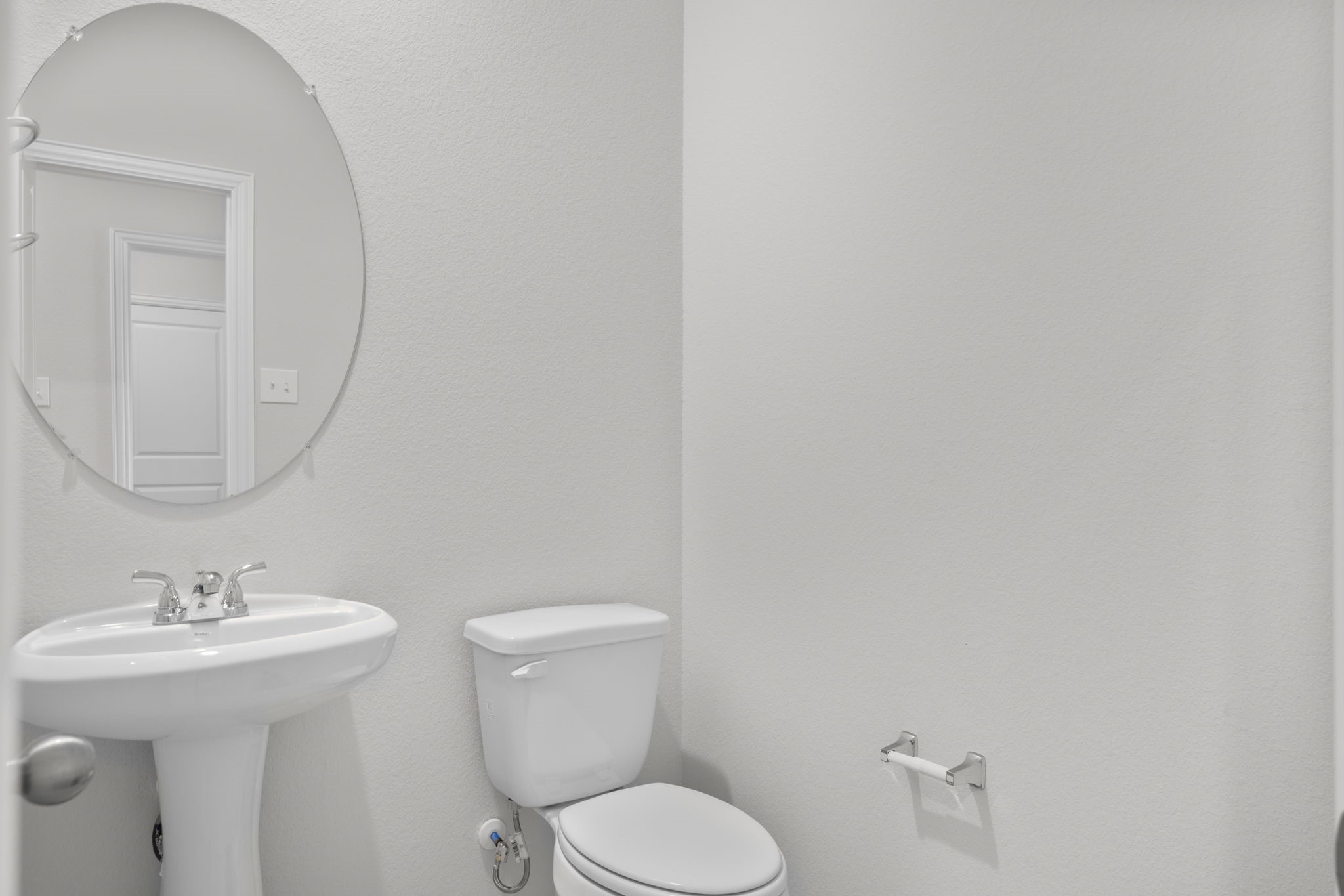 22223 Rome Breeze Drive Hockley, TX 77447 - Photo 11 of 46 The stylish half bath on the first floor features a pedestal sink, framed mirror, and soft neutral tones that create a crisp and welcoming atmosphere for guests. Perfectly positioned for convenience and privacy near the main living areas.