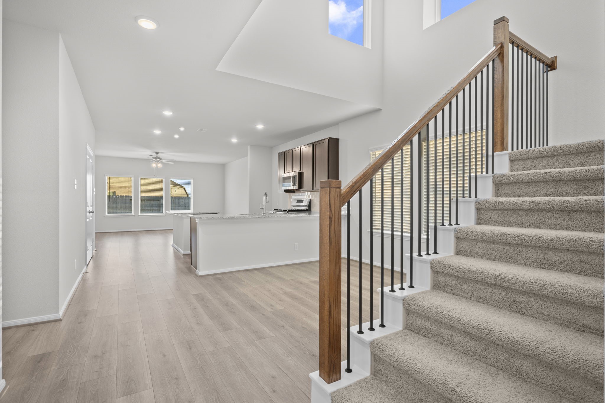 22223 Rome Breeze Drive Hockley, TX 77447 - Photo 20 of 46 The striking staircase with wrought-iron spindles and rich wooden accents adds a touch of elegance to the open-concept layout. Its placement connects the living, kitchen, and dining spaces beautifully while maintaining an open and inviting feel. Tile that looks like wood floors will lead you into the main living area and more! Let's discover what is upstairs. Better make that call and let me show you this stunning New Construction Home by CastleRock Communities Homes today, let us start memories!