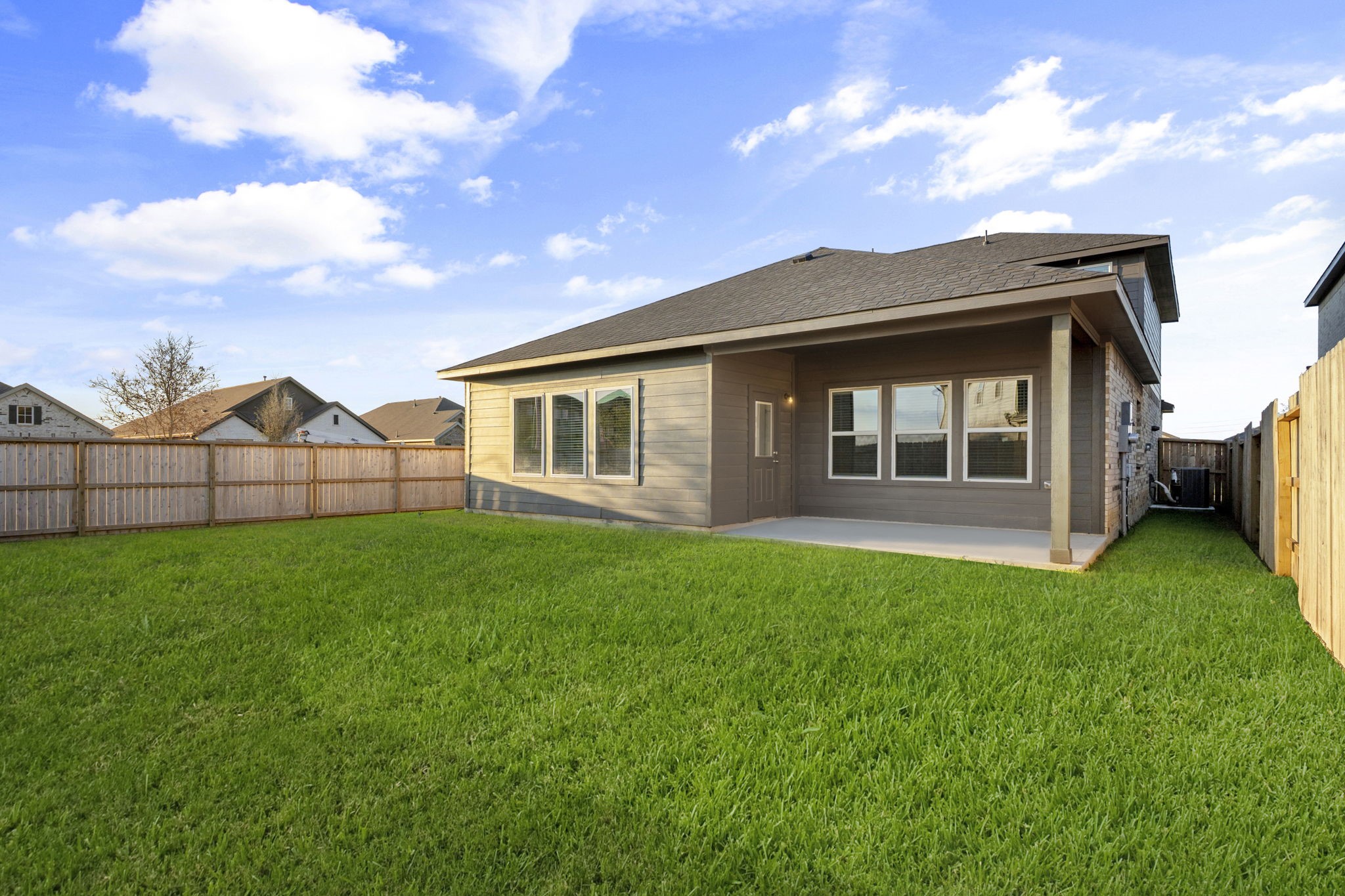 22223 Rome Breeze Drive Hockley, TX 77447 - Photo 30 of 46 A view of the backyard from another angle highlights its generous size and the home’s beautiful exterior design. The wide-open space is ideal for creating your dream outdoor retreat or hosting weekend barbecues.