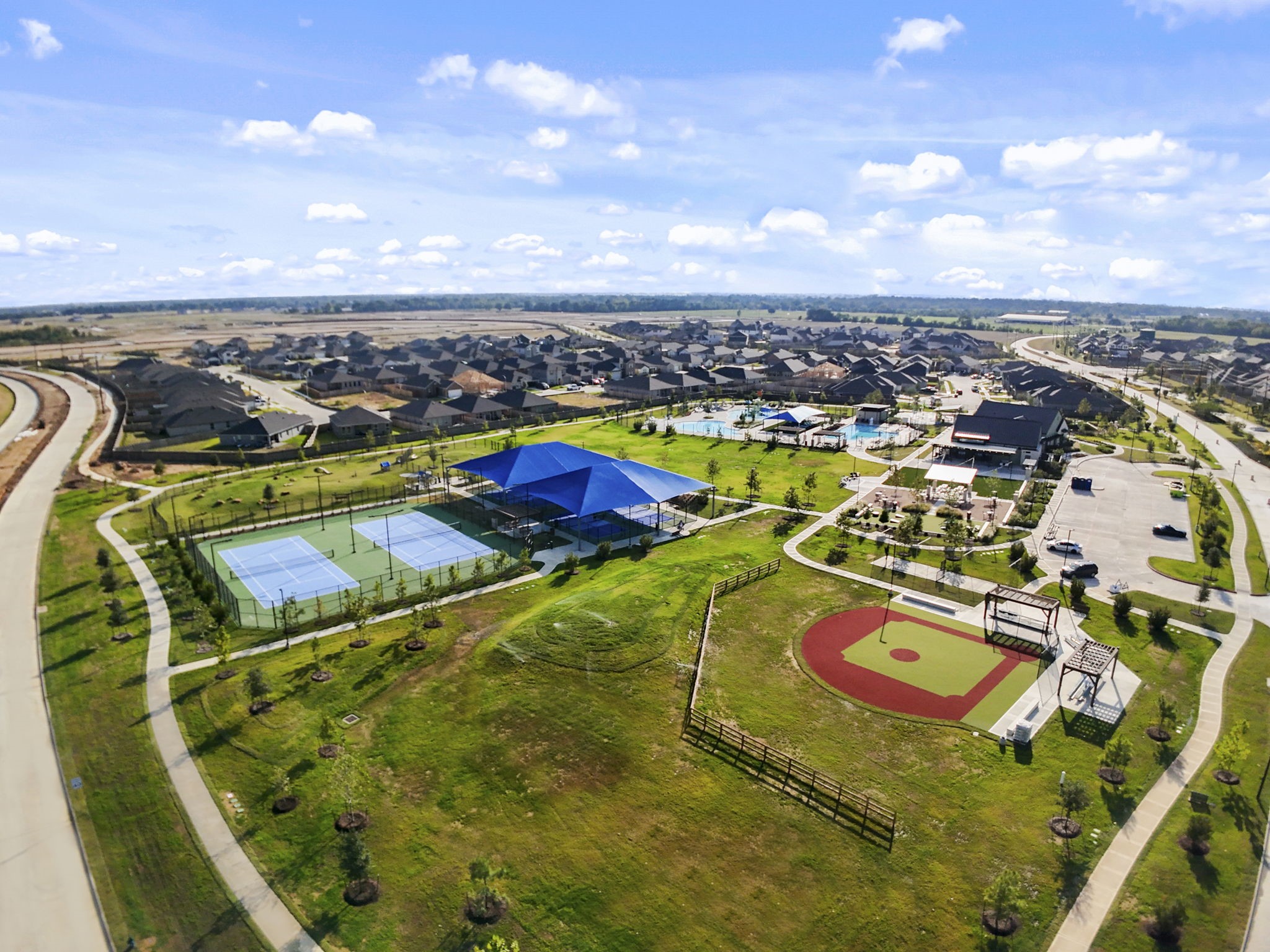 22223 Rome Breeze Drive Hockley, TX 77447 - Photo 37 of 46 Another aerial view reveals the community’s recreational spaces, including sports courts and beautifully maintained grounds. The area offers a welcoming atmosphere filled with activity and relaxation.