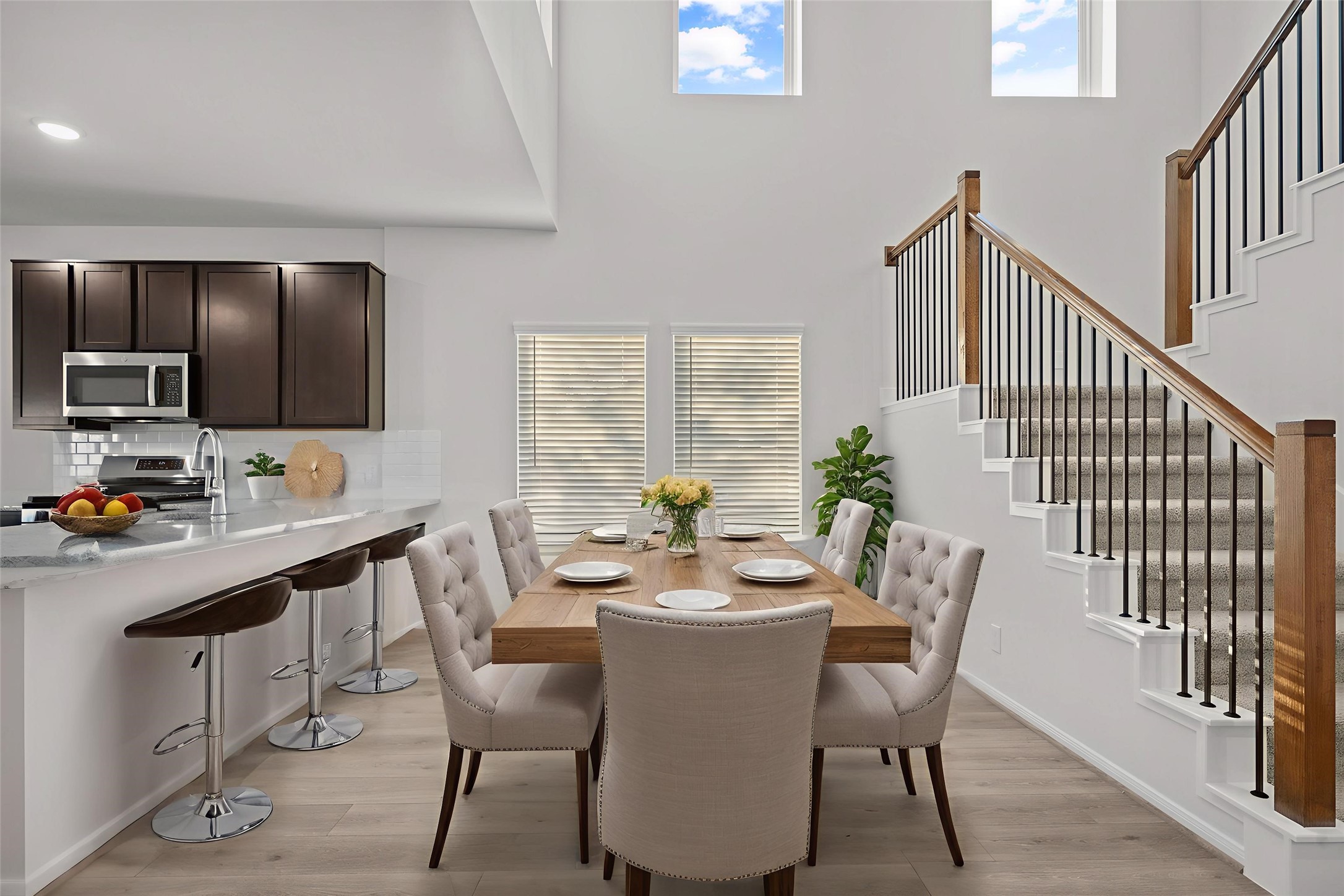 22223 Rome Breeze Drive Hockley, TX 77447 - Photo 45 of 46 This virtually staged kitchen and dining area showcases a warm and welcoming heart of the home. The space features a spacious breakfast bar, gleaming granite countertops, stylish cabinetry, and plenty of natural light, offering a perfect setting for gatherings or family meals. The Dramatic two-story wall of windows makes this floor plan timeless!