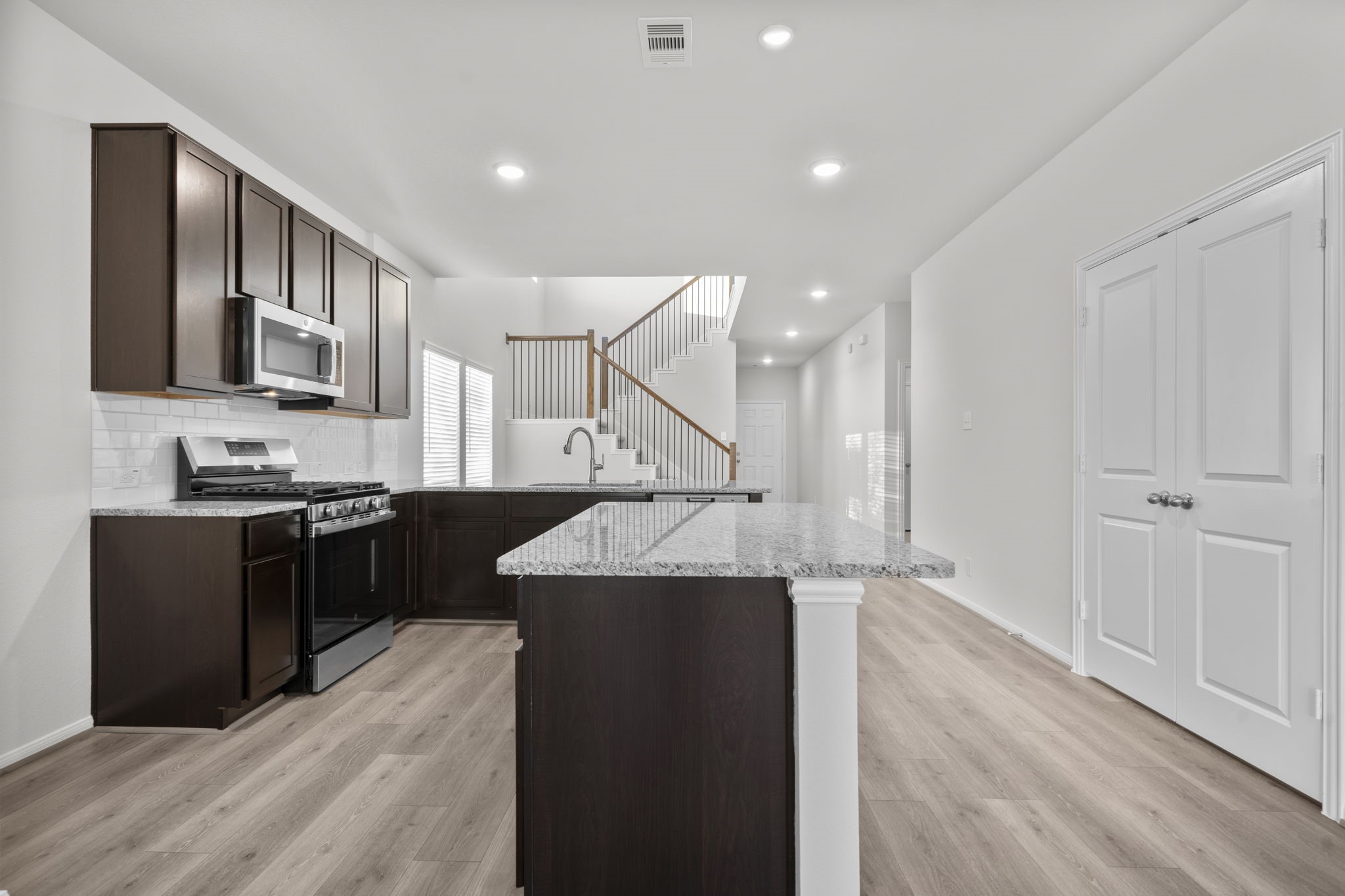 22223 Rome Breeze Drive Hockley, TX 77447 - Photo 8 of 46 A closer look at the gourmet kitchen reveals beautiful shaker-style cabinetry, sparkling granite surfaces, and a gas range ready for your favorite recipes. The open layout makes cooking and socializing easy, with views extending to the family room. To your right French doors open to large walk in pantry,