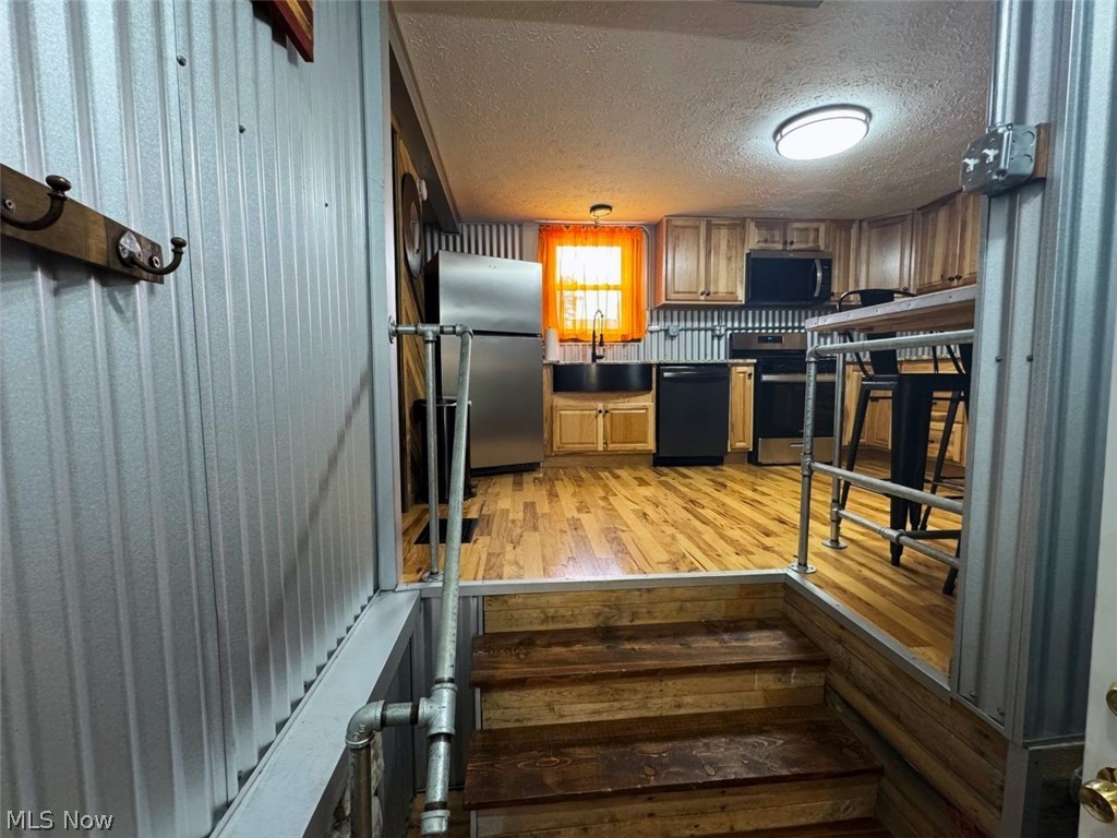 4421 State Road South Ashtabula, OH 44004 - Photo 6 of 18 Kitchen featuring stainless steel appliances, wood-finish flooring, wood cabinetry, and a black sink