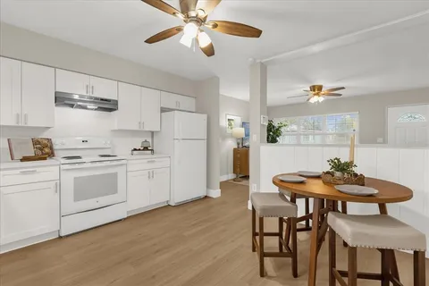 a kitchen with stainless steel appliances a table and chairs in it