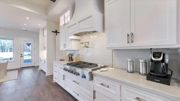 a kitchen with white cabinets and a stove