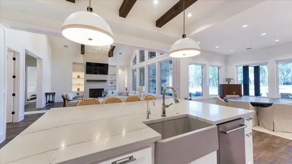 a large kitchen with kitchen island a large counter top space a sink stainless steel appliances and cabinets