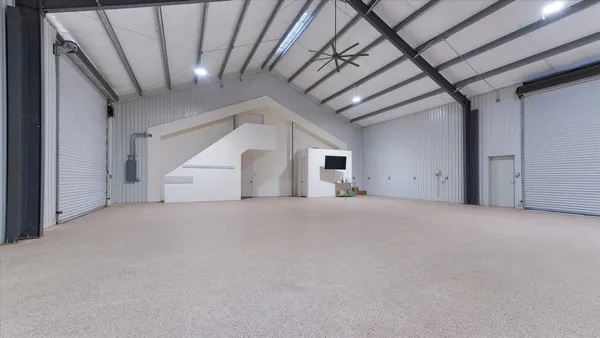 a view of a livingroom with furniture wooden floor a ceiling fan and windows
