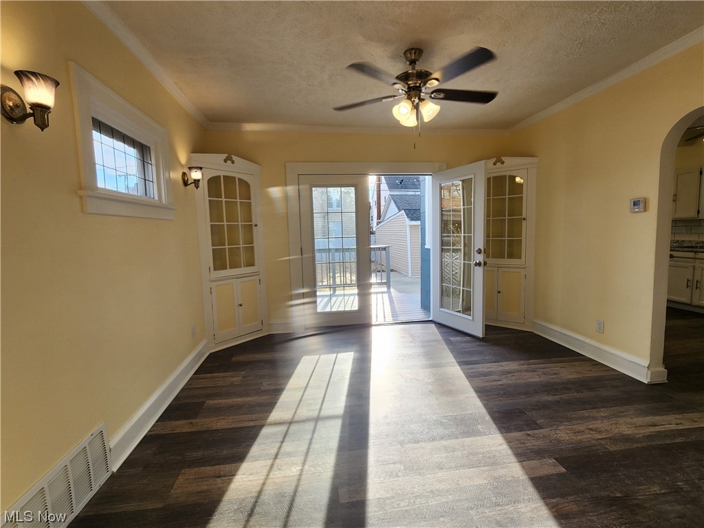 17814 Crestland Road Cleveland, OH 44119 - Photo 11 of 49 Spare room with dark hardwood / wood-style flooring, ceiling fan, a textured ceiling, and a healthy amount of sunlight
