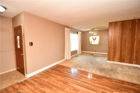 a view of a livingroom with wooden floor and a kitchen space