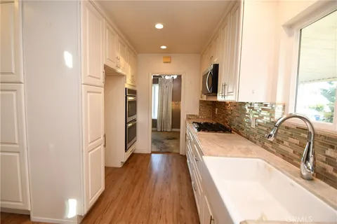 a kitchen with a sink microwave and cabinets