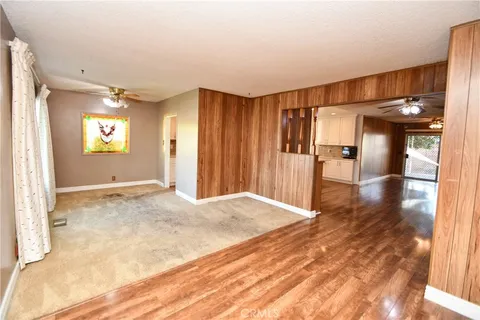 a view of a livingroom with a chandelier fan and a bathroom