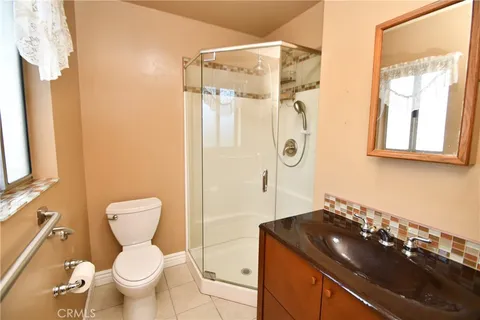 a bathroom with a granite countertop sink toilet and shower