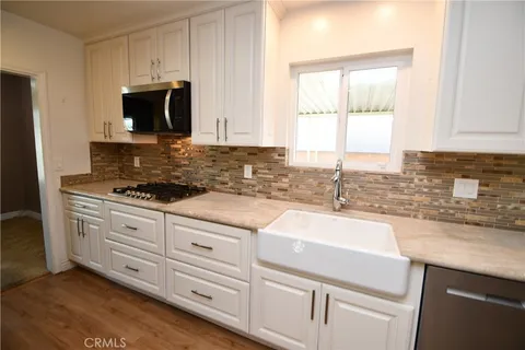 a kitchen with granite countertop white cabinets and a sink