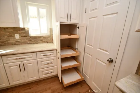 a kitchen with granite countertop a refrigerator and cabinets