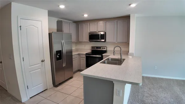 a kitchen with stainless steel appliances granite countertop a refrigerator and a sink