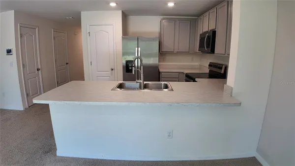 a kitchen with stainless steel appliances a refrigerator and a sink