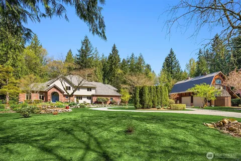 a view of house with garden and tall trees