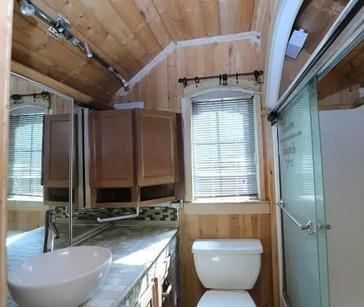 a bathroom with a granite countertop sink a toilet and a mirror