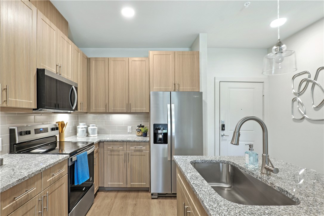 6000 Jones Road, Unit 4301 Bryan, TX 77807 - Photo 10 of 16 a kitchen with stainless steel appliances granite countertop a sink stove and refrigerator