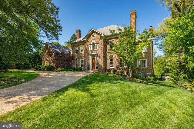 a view of a house with a small yard and large tree