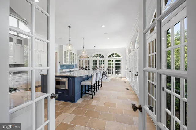 a large white kitchen with granite countertop a large window and a sink