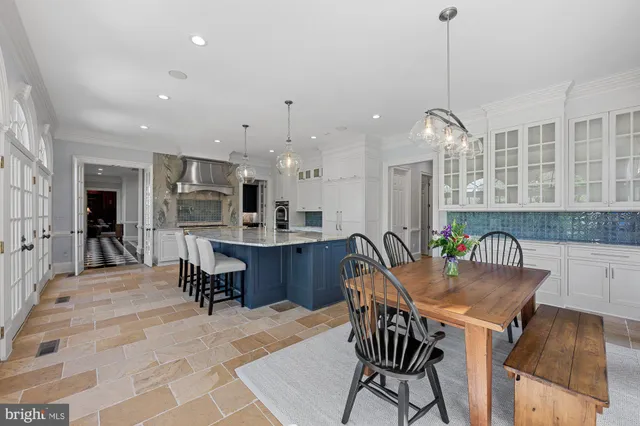 a kitchen with a dining table chairs sink and cabinets