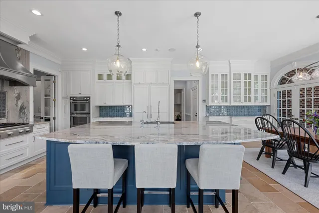 a kitchen with center island table and chairs in it