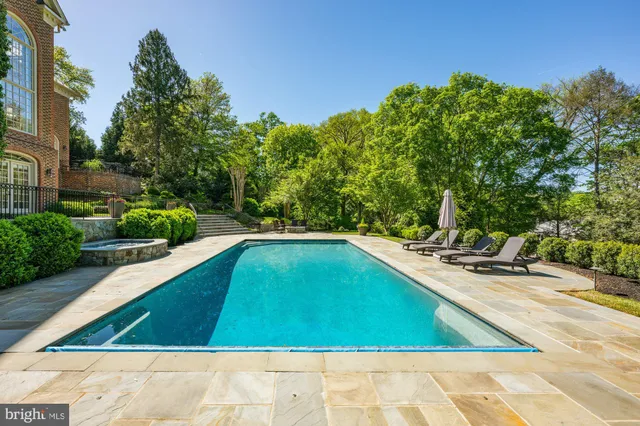 a view of swimming pool on a sunny day with lawn chairs
