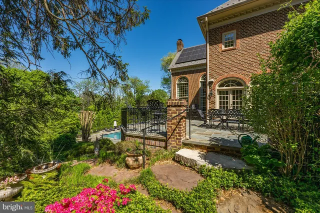 a front view of a house with garden and sitting area