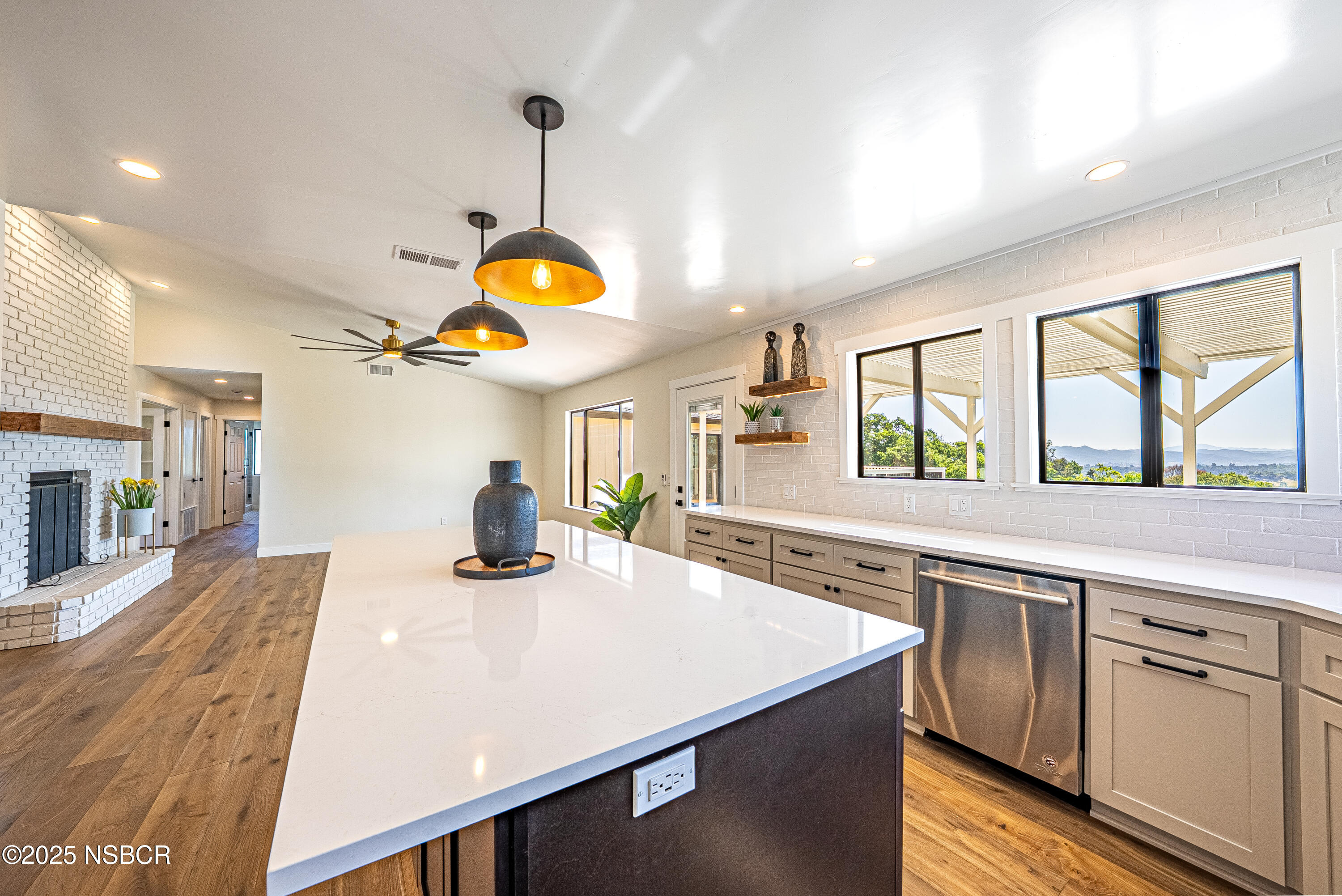 10095 San Marcos Road Atascadero, CA 93422 - Photo 30 of 58 a kitchen with a stove a sink a dining table and chairs with wooden floor