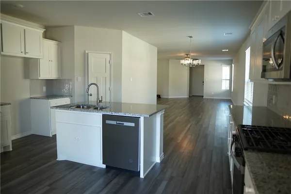 a kitchen with a refrigerator and a stove top oven