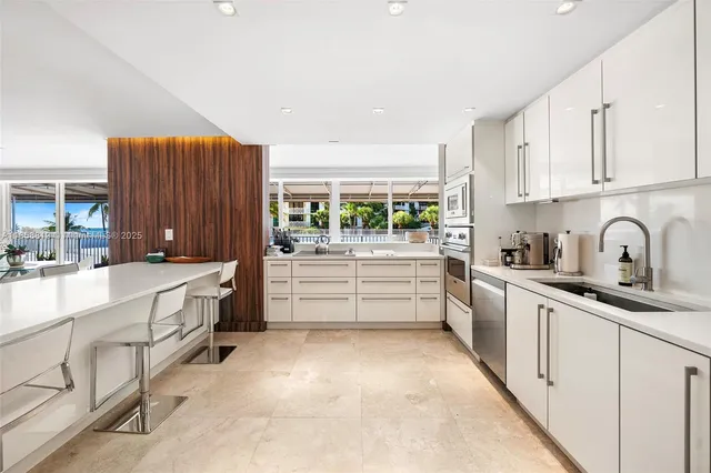 a kitchen with granite countertop a sink and white cabinets