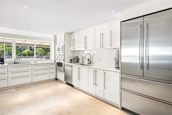 a kitchen with white cabinets and white appliances