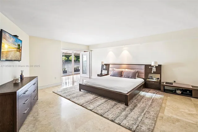 a bedroom with a large bed and a flat tv screen on dresser