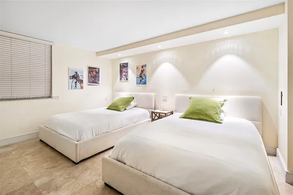 a bedroom with two beds and painting on the wall